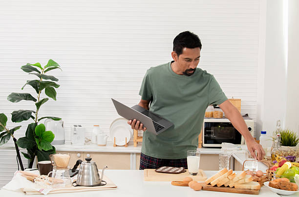 istock Creative professional multitask effortlessly as the morning sun, man focused gaze on laptop screen new project work from home, snapshot captures a modern lifestyle meets productive energy arrangement 2211911545