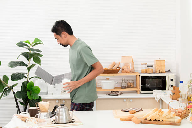 Creative professional multitask effortlessly as the morning sun, man focused gaze on laptop screen new project work from home, snapshot captures a modern lifestyle meets productive energy arrangement