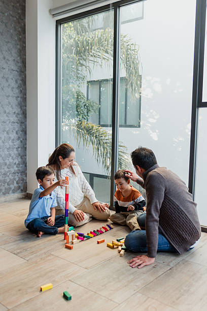 young latin parents playing with children at home in Mexico Latin America, hispanic family with son having fun stock photo
