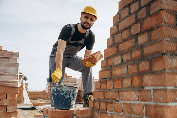 istock In uniform and hard hat. Construction worker is at job with bricks outdoors 2211912665