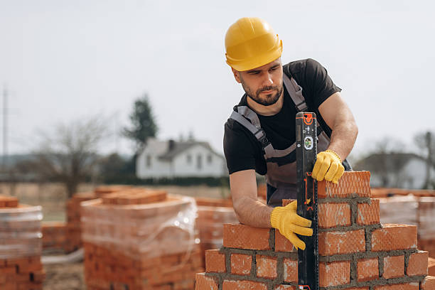 istock Orange colored hard hat. Construction worker is at job with bricks outdoors 2211912745