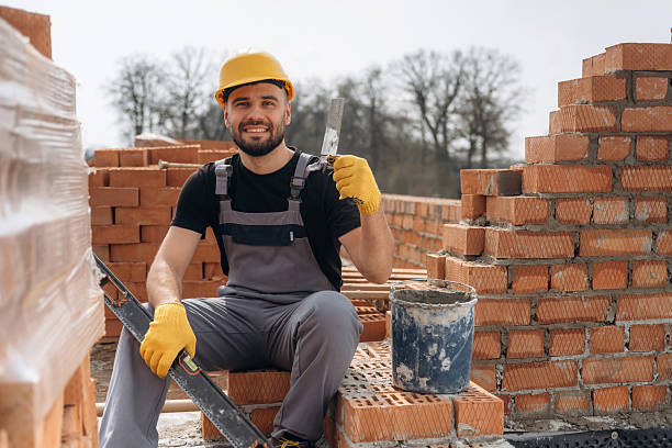 istock Cheerful positive guy. Construction worker is at job with bricks outdoors 2211912944