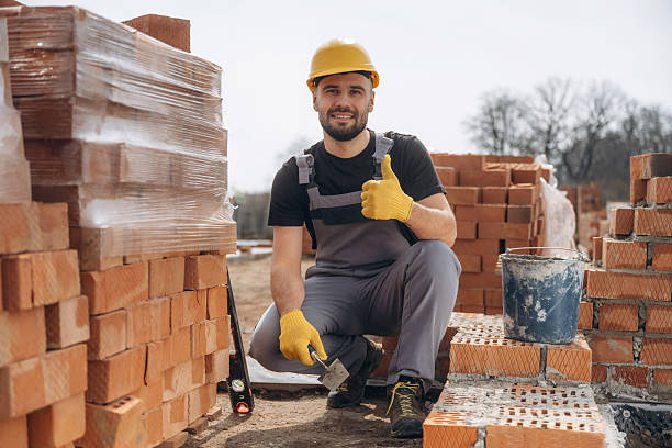istock Cheerful positive guy. Construction worker is at job with bricks outdoors 2211912974