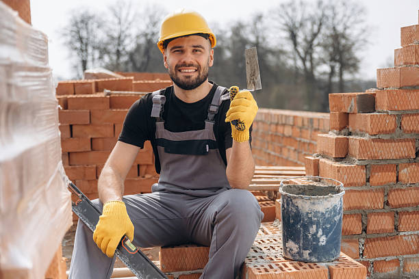 istock Cheerful positive guy. Construction worker is at job with bricks outdoors 2211912982