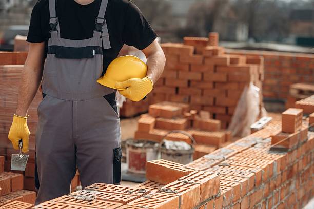 istock Holding hard hat. Close up view of construction man that is working with bricks 2211913009