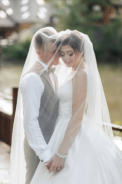 istock A bride and groom are embracing each other under a veil 2211913345