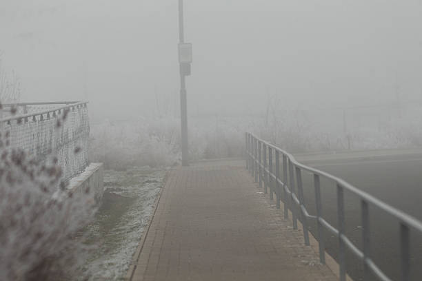 A fogcovered walkway adorned with railings, vividly illustrating an eerie and mysterious atmospheric condition that captivates