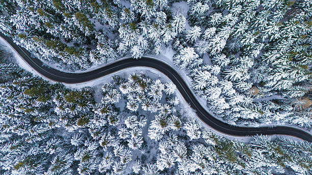 istock Winding Winter Road Through Snow-Covered Trees. Drone view 2211914951