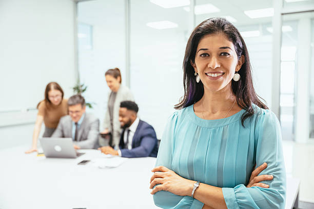 istock Multicultural corporate business people working in modern bright office on laptops and tablets. Latin businesswoman looking at camera 2211915097
