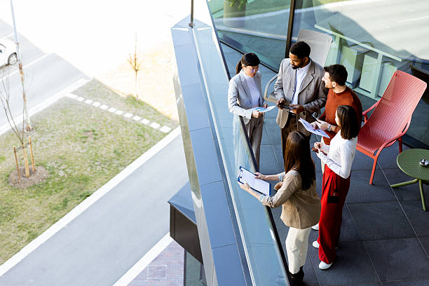 istock Group of professionals collaborating on project details in modern office space during sunny day 2211916271