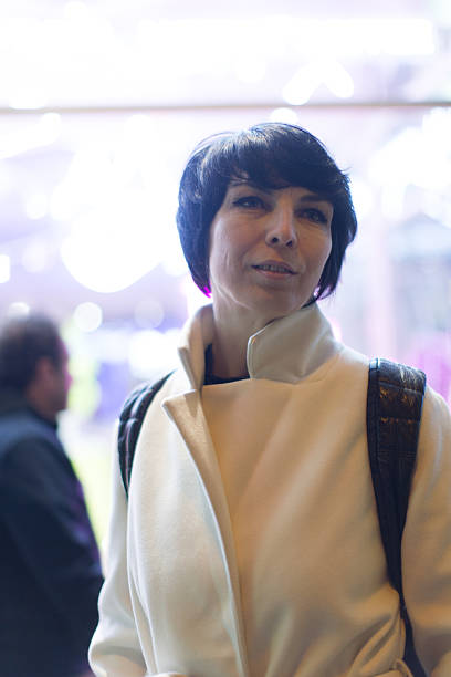 istock An Elegant Woman Dressed in a White Coat Attending a Venue Event 2211917814