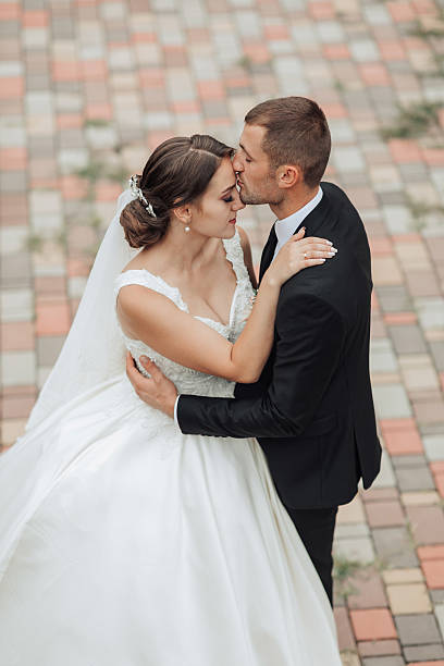 istock A bride and groom are kissing on a brick walkway 2211921022