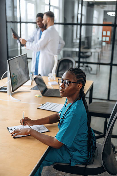 istock Men behind are looking at x-ray. Doctors are working in the office 2211922159