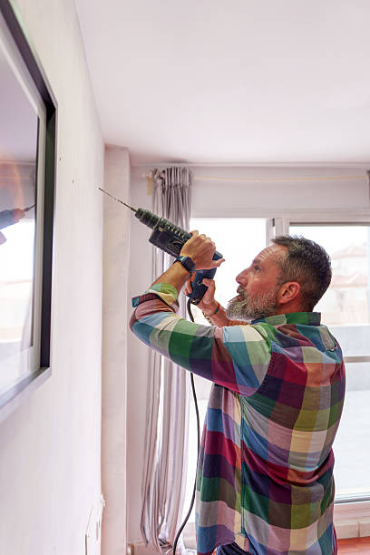 istock Handyman drilling the wall to hang a frame using a drill 2211923143