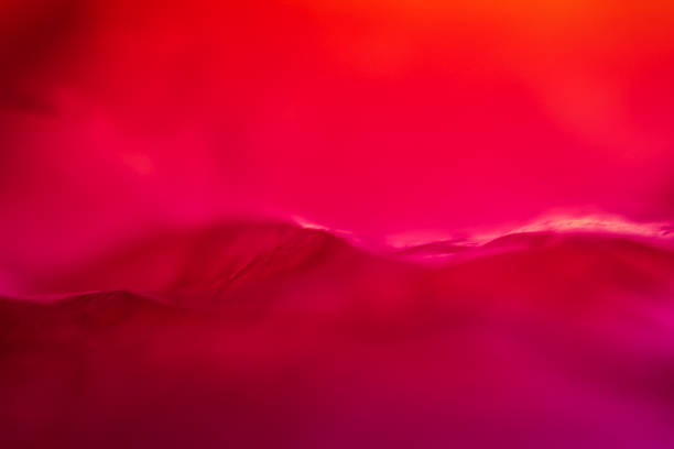 Extreme close up of red empty plastic bag background. The plastic surface is wrinkly and tattered making abstract pattern. Selective focus, shallow depth of field.