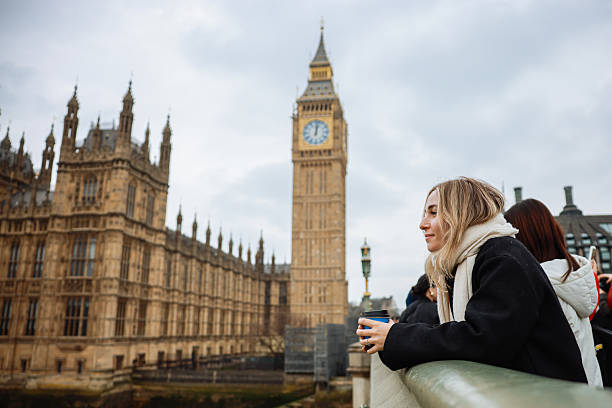 istock Young woman drinking coffee in a disposable cup on Westminster Bridge 2211924513