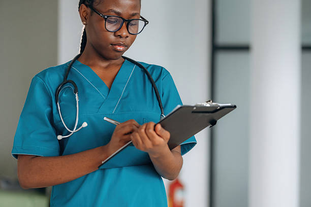 istock Writing information into documents. Female doctor is indoors in modern room 2211925938