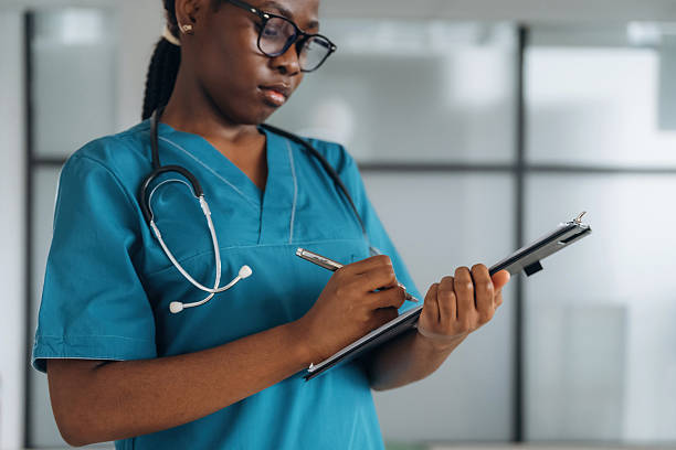 istock Writing information into documents. Female doctor is indoors in modern room 2211926061