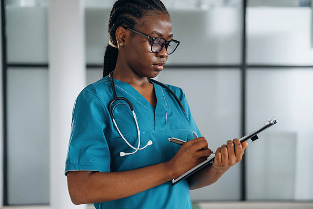 istock Writing information into documents. Female doctor is indoors in modern room 2211926072