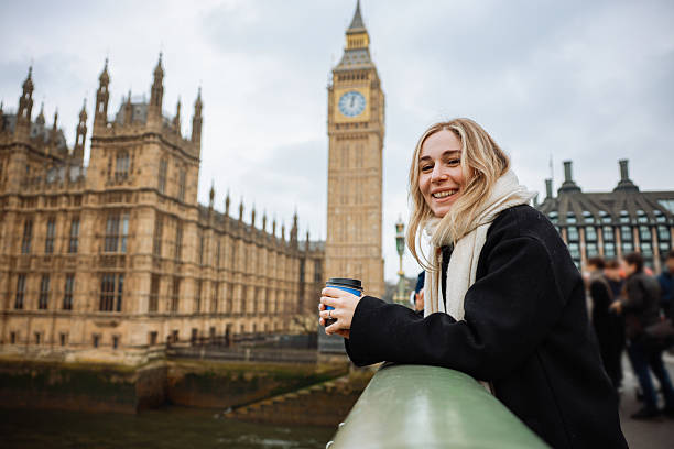istock Young woman drinking coffee in a disposable cup on Westminster Bridge 2211926224