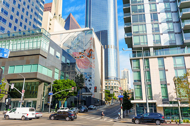 Los Angeles, California - December 3, 2024: Wide angle view of the bustling intersection at W 5th St and S Olive St in downtown Los Angeles, showcasing modern architecture and street art.