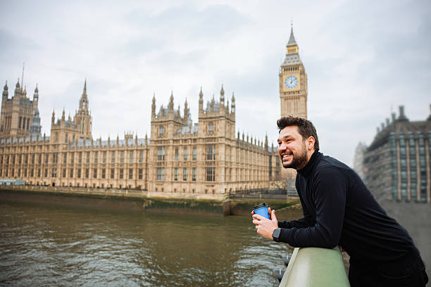 istock Young man drinking coffee in a disposable cup on Westminster Bridge 2211926901