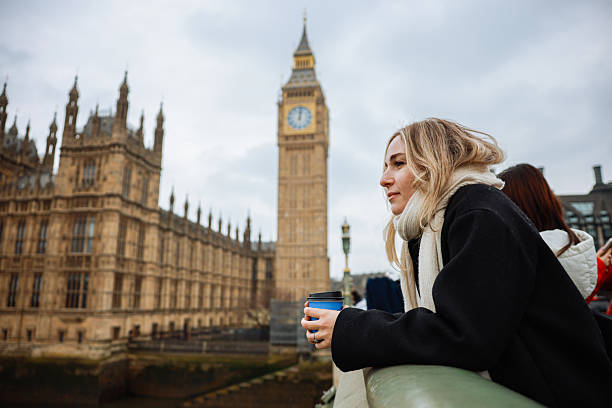 istock Young woman drinking coffee in a disposable cup on Westminster Bridge 2211928326