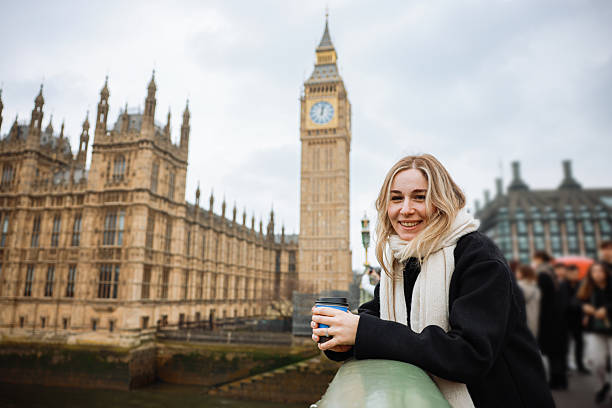 istock Young woman drinking coffee in a disposable cup on Westminster Bridge 2211934479