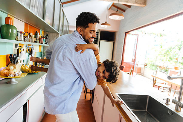 istock Father and son playing together in a modern kitchen setting 2211934655