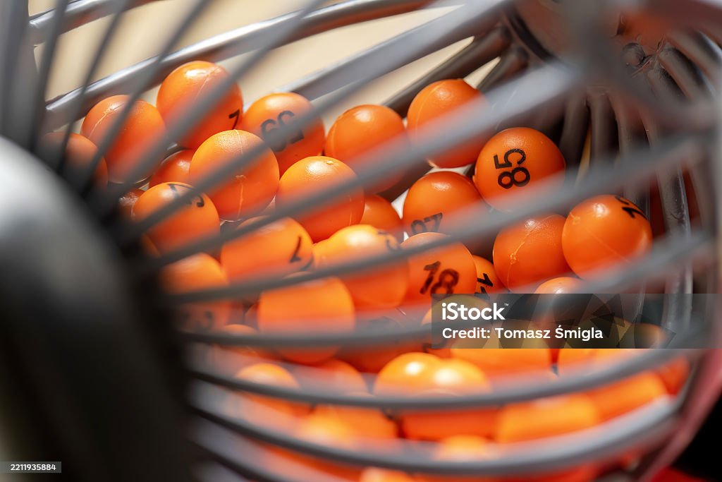 Extreme Nahaufnahme von orangefarbenen nummerierten Lotteriekugeln in einem sich drehenden Käfig, Konzept des Zufalls, Bingospiel, Glücksspiel, Zeichensystem oder Tombola-Mechanismus, bunter abstrakter Hintergrund, keine Menschen - Lizenzfrei Bingo Stock-Foto Extreme Nahaufnahme von orangefarbenen nummerierten Lotteriekugeln in einem sich drehenden Käfig, Konzept des Zufalls, Bingospiel, Glücksspiel, Zeichensystem oder Tombola-Mechanismus, bunter abstrakter Hintergrund, keine Menschen - Lizenzfrei Bingo Stock-Foto