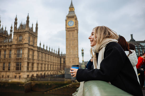 istock Young woman drinking coffee in a disposable cup on Westminster Bridge 2211938207