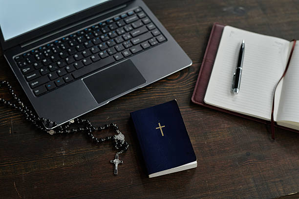 istock Laptop, Bible and Rosary on Desk 2211939936
