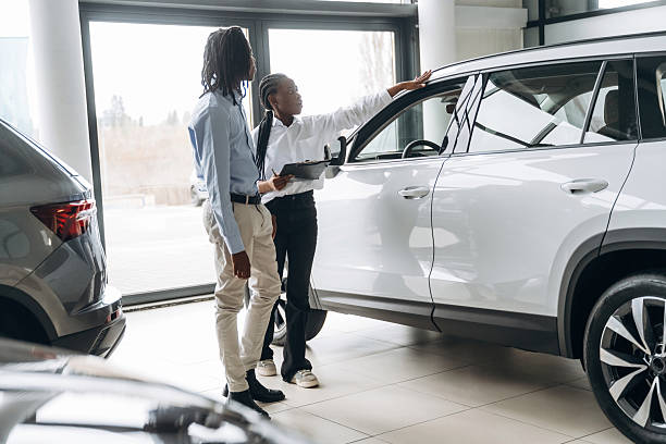 istock Explaining details. Car seller is assisting client in the automobile salon 2211941985