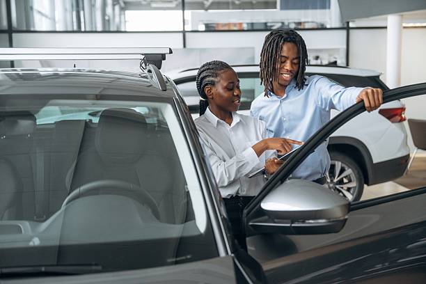 istock Documents in hands. Car seller is assisting client in the automobile salon 2211942256