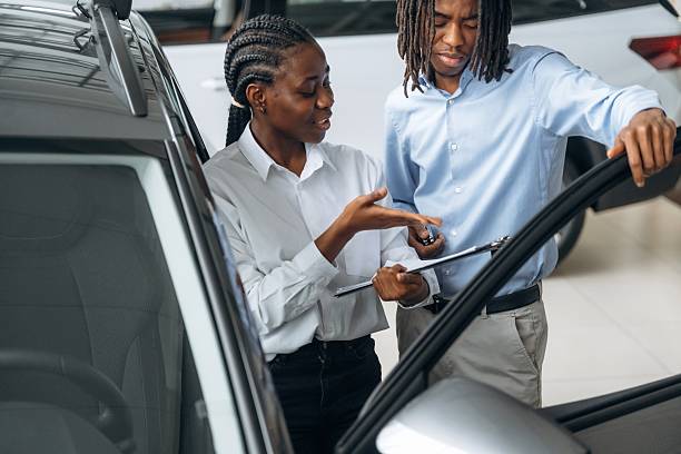 istock Documents in hands. Car seller is assisting client in the automobile salon 2211942292