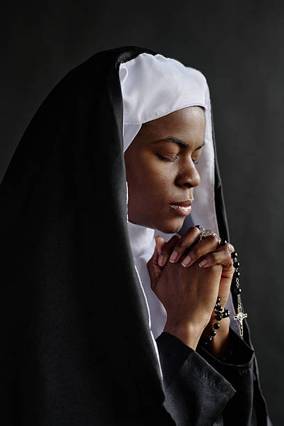 istock Profile of Praying Nun 2211942648