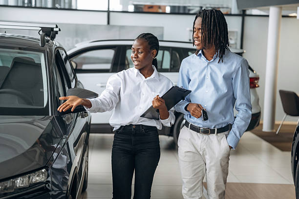 istock Documents in hands. Car seller is assisting client in the automobile salon 2211944248