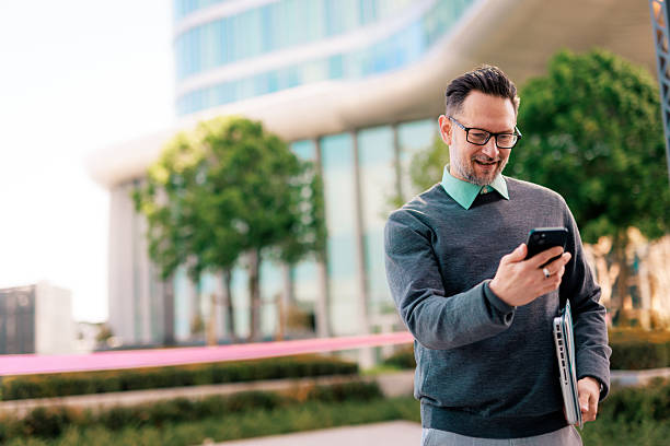 istock Businessman using smartphone outside office building 2211949008