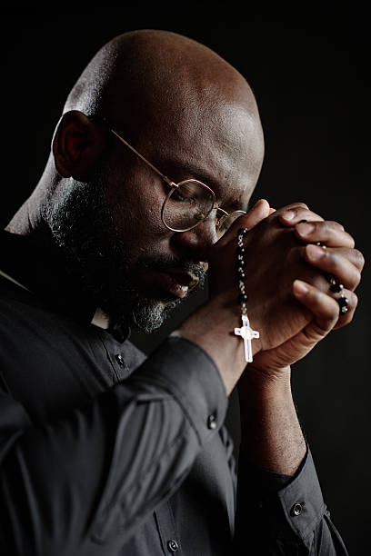 istock Priest Praying with Rosary in Hands 2211949238