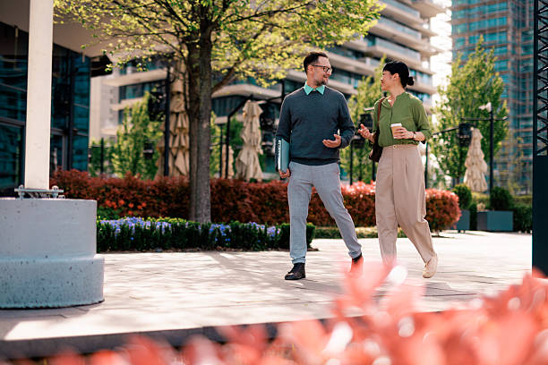 istock Two business people walking and talking in a modern city 2211951130