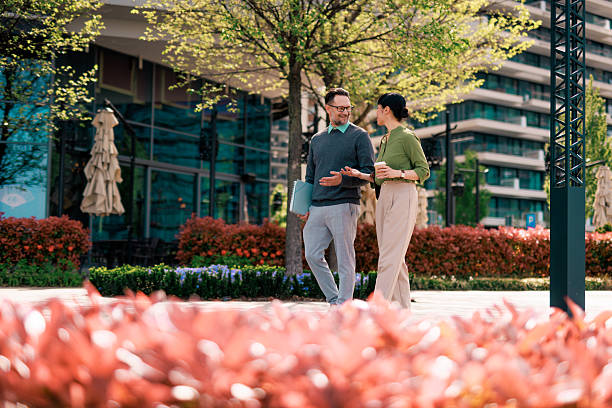 Two colleagues walking and talking during their coffee break