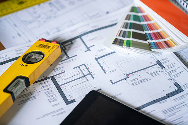 Architectural Plans with Measuring Tool and Color Palette Arranged on a Desk