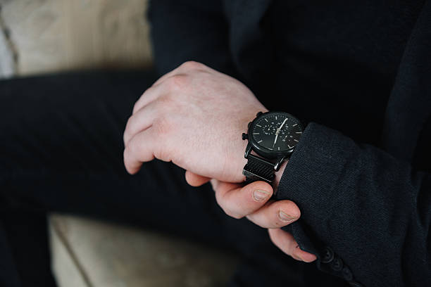 istock man looks at his watch on hand 2211952847