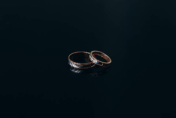istock wedding rings in black background 2211955677