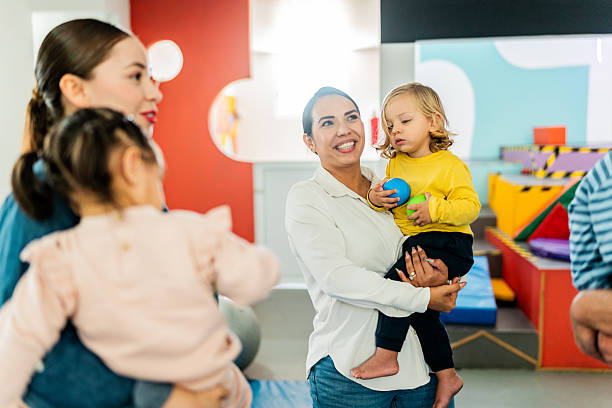 istock Mothers carrying babies and talking at playroom 2211957906