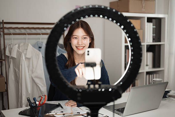 istock A young entrepreneur smiles at the camera through a ring light while setting up a live streaming session, Live Selling in Action: Engaging Customers Online 2211958695