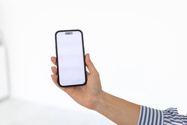 istock Young woman engages with mobile app on phone against a clean white backdrop while expressing joy and connection 2211959528