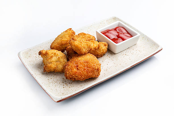 istock Nuggets in breadcrumbs on a light plate with ketchup. On a white background 2211959604
