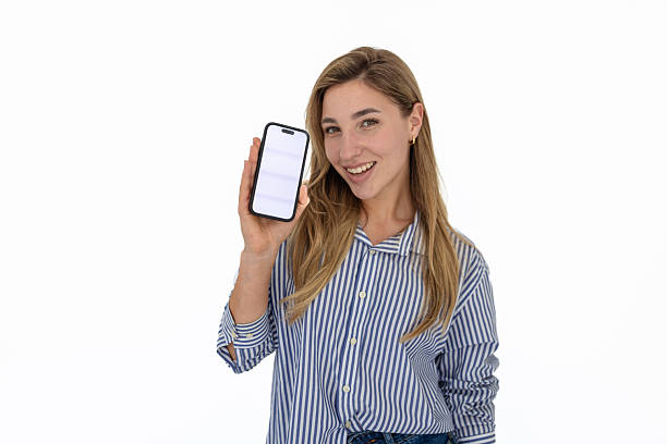 istock Young woman interacting with mobile app on smartphone against a blank white background, showcasing digital engagement and connectivity 2211960983