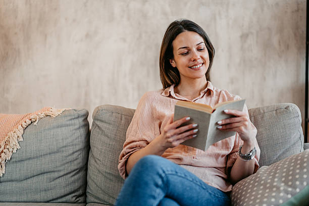istock Young Woman Reading A Book At Home 2211961111